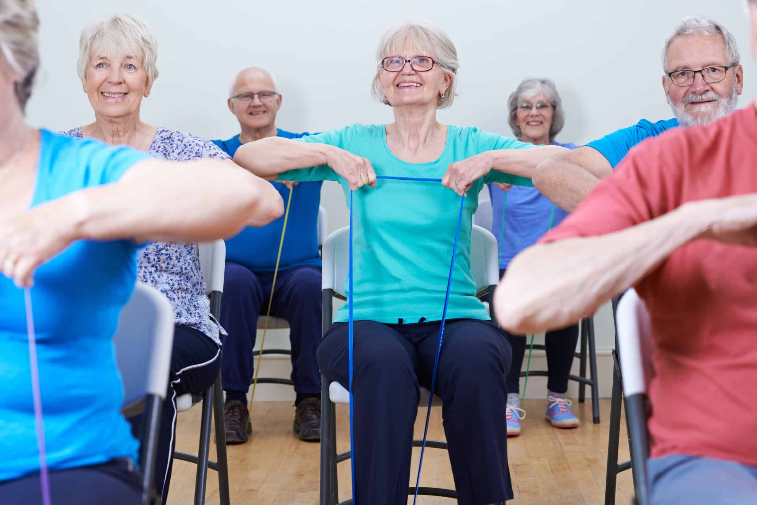 senior citizens participating in a low-impact chair aerobics class in a  small village hall in west wales UK Stock Photo - Alamy