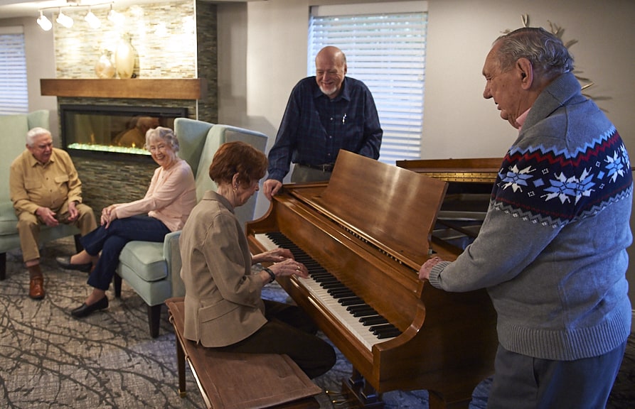 Senior Residents sitting around the piano.